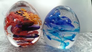 glass paperweight eggs - a red, purple, orange and a light and dark blue