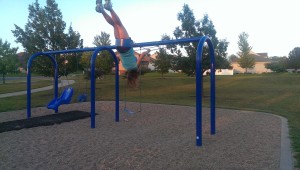 woman swinging upside down on swingset