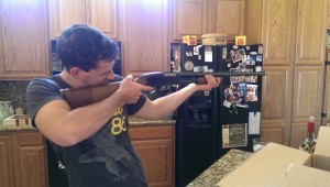 man aiming gun indoors rifle kitchen