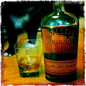 Bulleit burbon whiskey in a glass with bottle