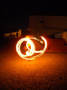 A fire twirler fire twirling seen by Half the Clothes Author Jema Patterson on her trip to Portugal