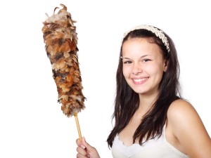 this cute girl holding a feather duster would be smiling if she was doing hostel work - not one of the best travel jobs